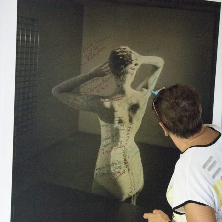 Les couturières signent une photo d'une de leur création, le corset